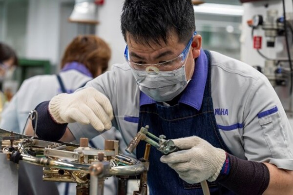 Um artesão a soldar peças metálicas com solda sem chumbo.