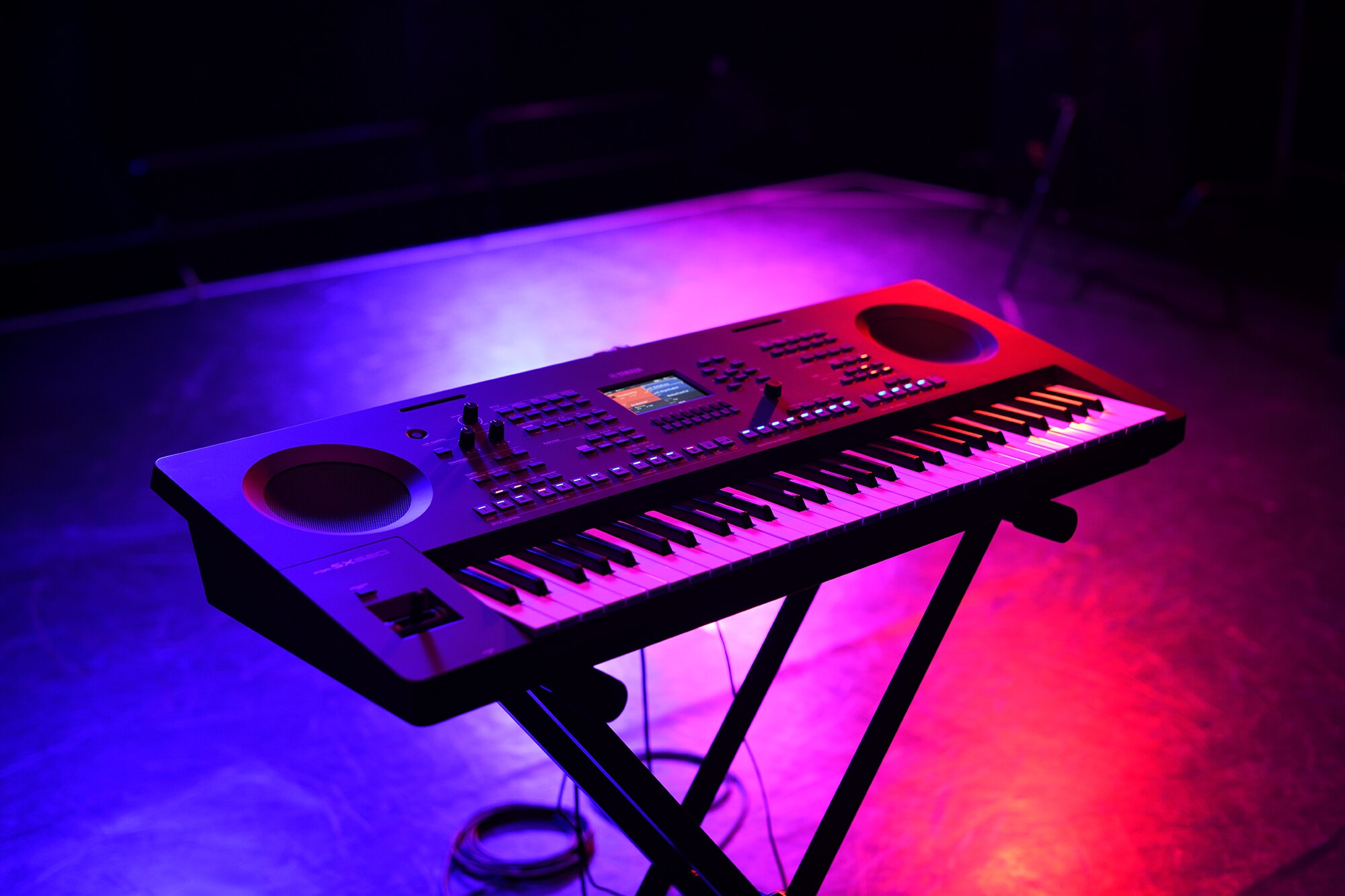 Um teclado num suporte sob iluminação de palco