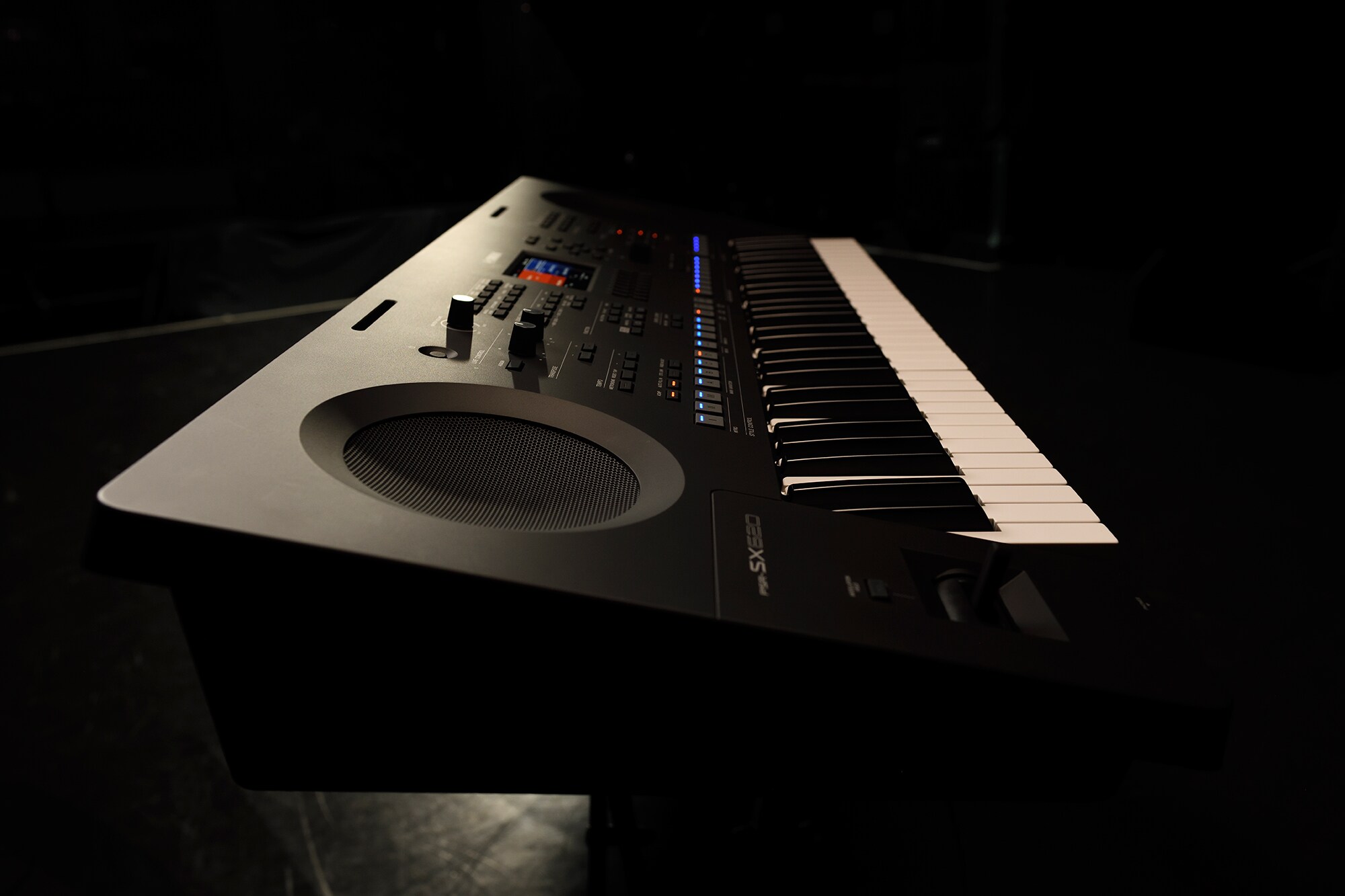 Um teclado num suporte sob iluminação de palco