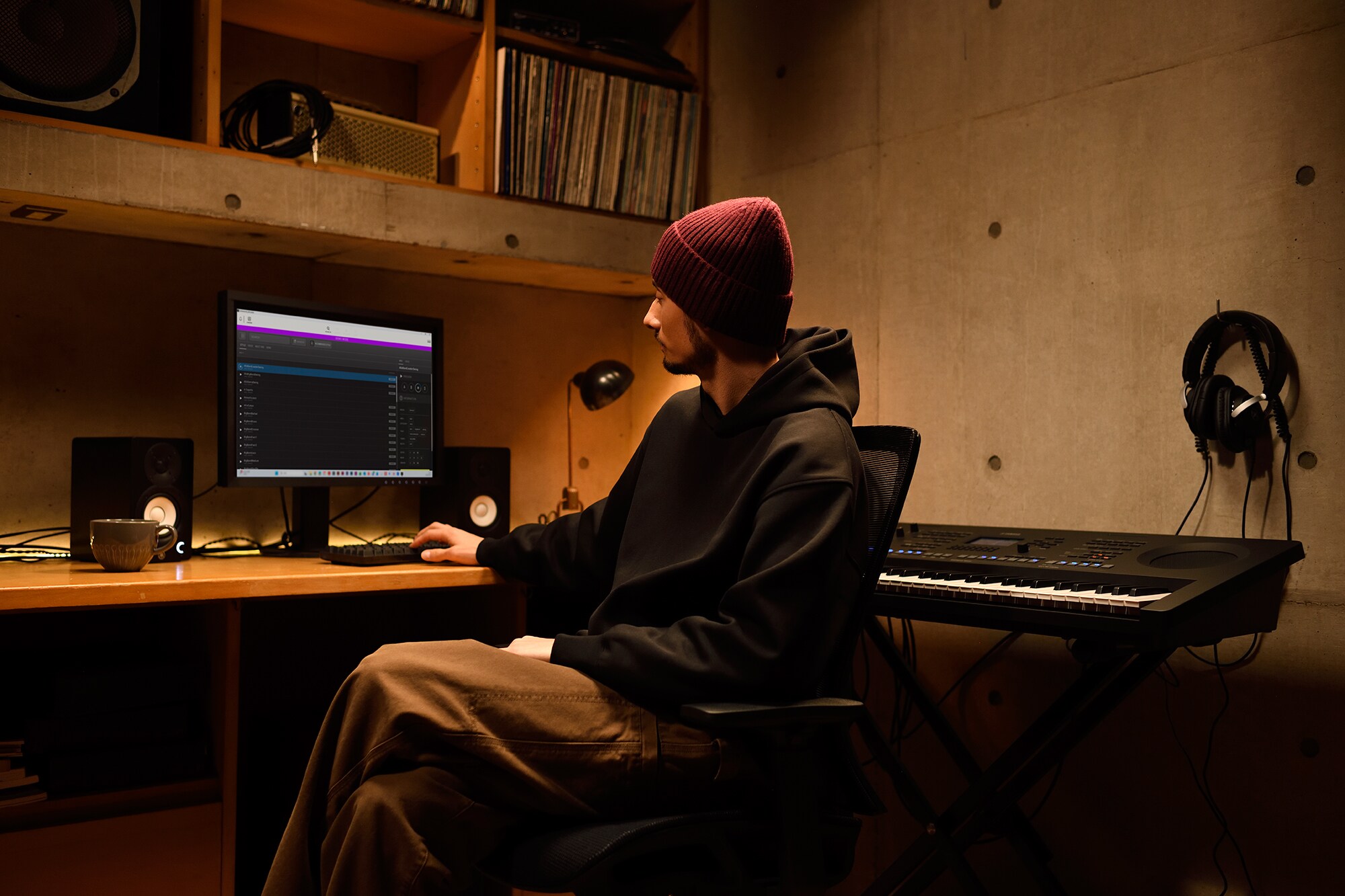 Um espaço de trabalho musical em casa com um computador e um teclado, mostrando um teclista a trabalhar no seu estúdio caseiro