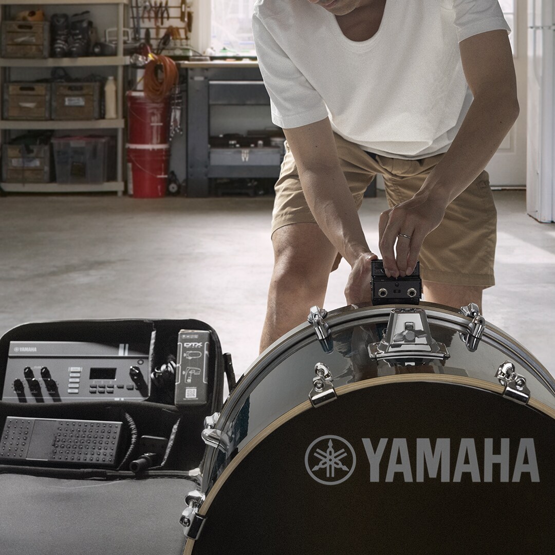 Baterista a fixar a unidade de sensor do EAD20 num bombo para uma configuração rápida e captação otimizada do som da bateria.