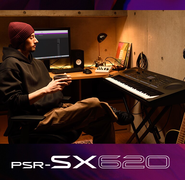 Pessoa sentada junto a um teclado PSR-SX num estúdio caseiro, a beber café.