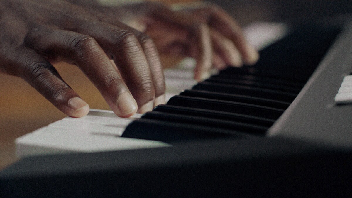 Teclado do PSR-E483 a ser tocado por uma pessoa