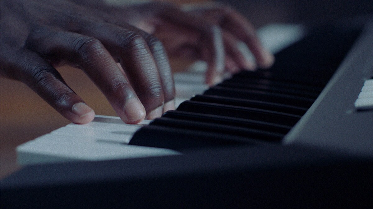 Teclado do PSR-E583 a ser tocado por uma pessoa