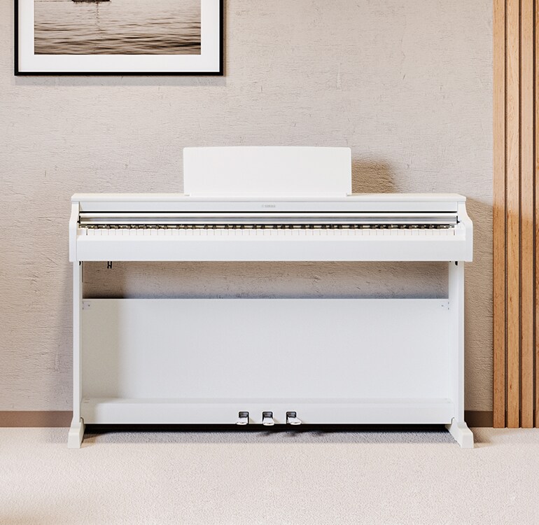 Uma sala de estar com um piano ARIUS em branco, plantas de interior e um sofá, harmoniosamente integrado no interior