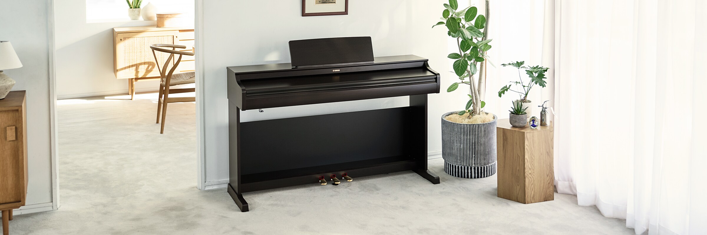 Um piano ARIUS numa sala de estar, com a tampa fechada e integrado naturalmente na decoração