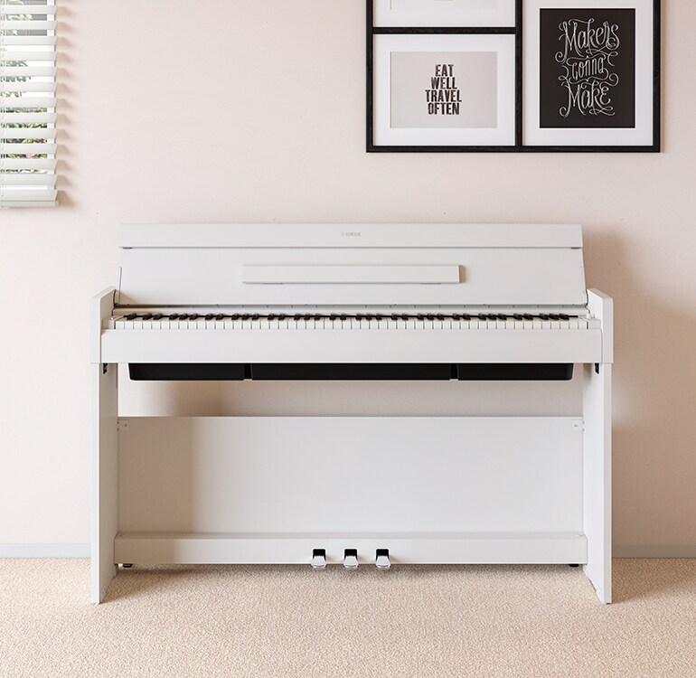 Uma sala de estar com um piano ARIUS em branco, colocado junto a prateleiras de parede com candeeiros e um difusor, integrado harmoniosamente na decoração