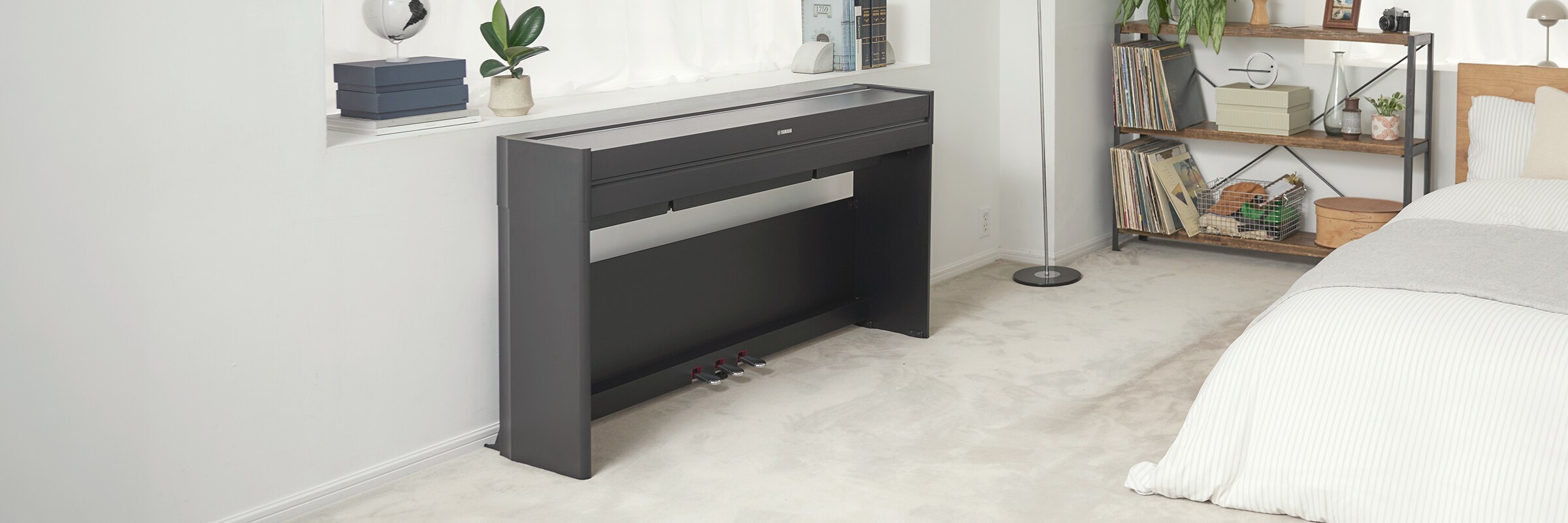 Um piano ARIUS num quarto, com a tampa fechada e integrado naturalmente na decoração.